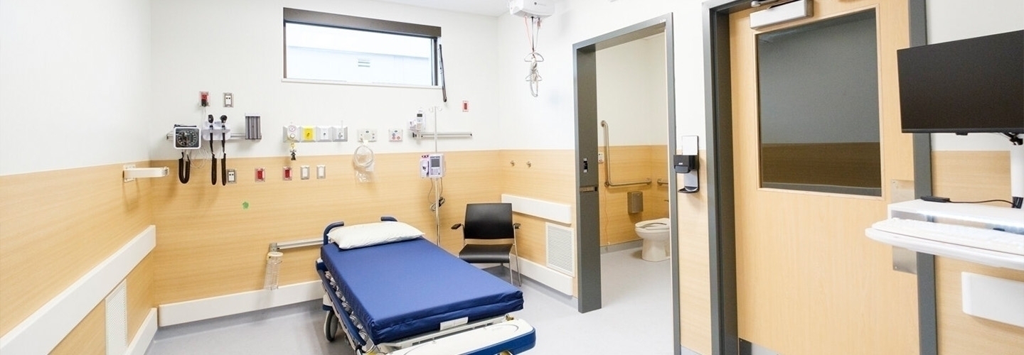 wide shot of a hospital room with a bed and washroom