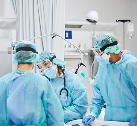 doctors in PPE performing a surgery